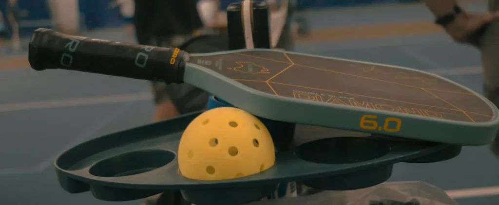The Wembley Club pickleball paddle and ball on a court