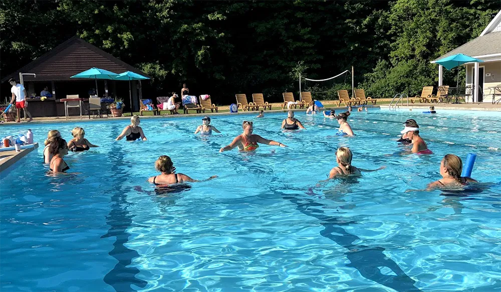 Adults taking a water fitness class in the outdoor pool at The Wembley Club in Chagrin Falls