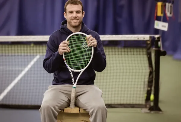 Tennis player holding a racquet on an indoor court at The Wembley Club